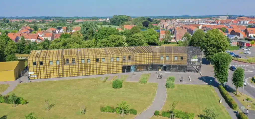 Bâtiment moderne avec parc en arrière-plan urbain.