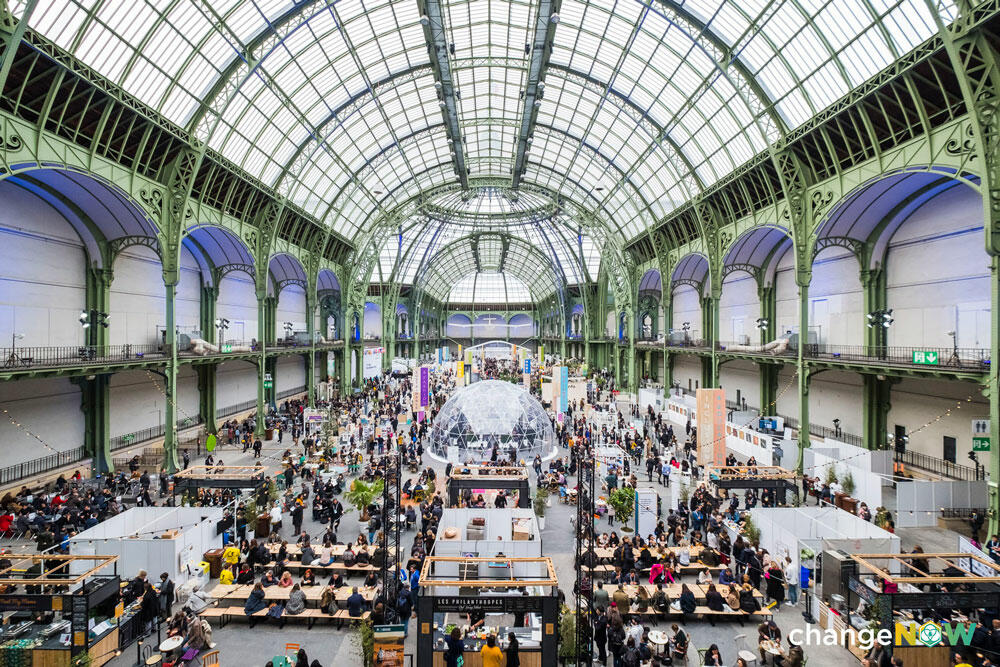 Grand hall bondé avec des stands et visiteurs