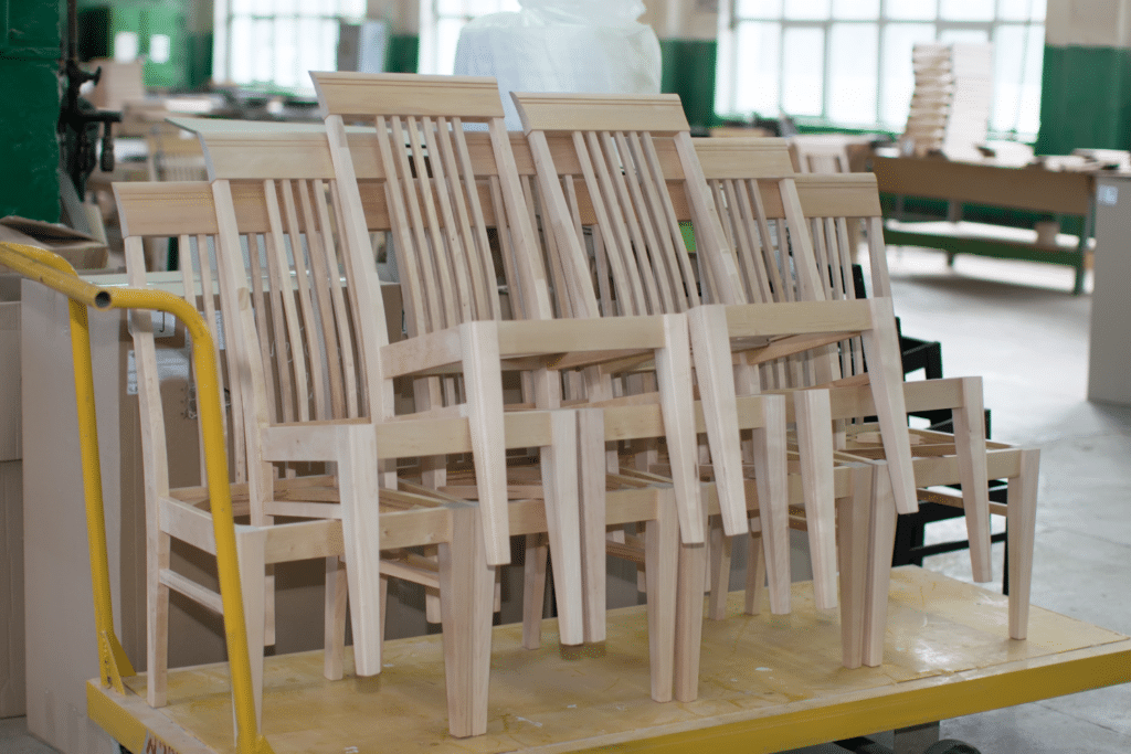 Chaises en bois non finies dans un atelier.
