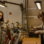 Deux femmes travaillent sur des objets en cuir.