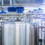 Réservoirs industriels en inox avec tuyauterie.