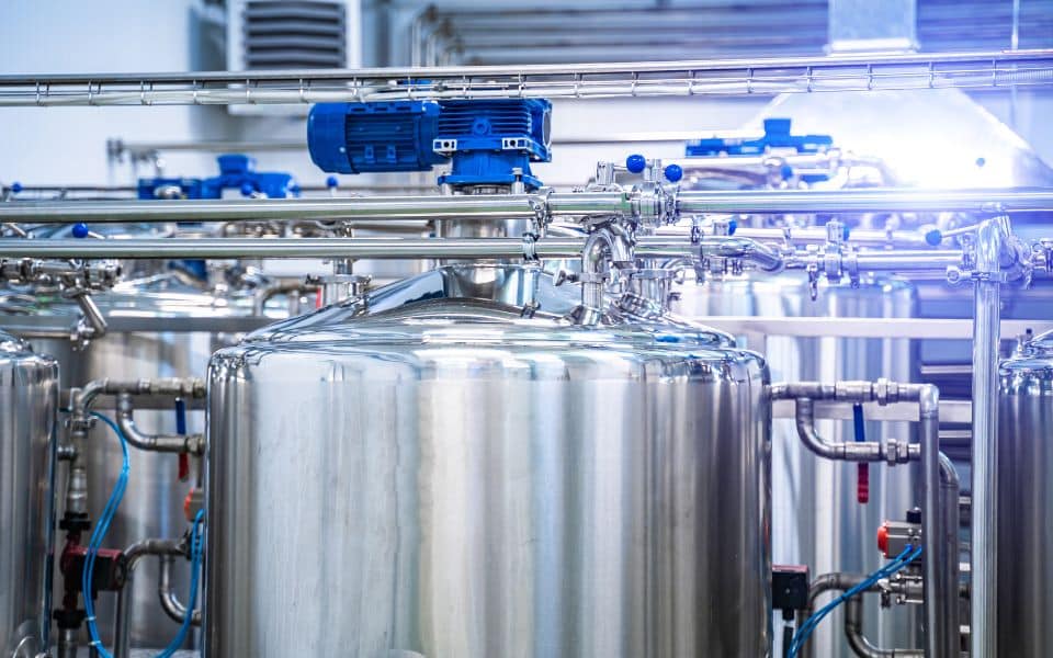 Réservoirs industriels en inox avec tuyauterie.