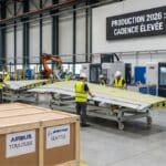 Ouvriers assemblent pièce d'avion dans usine moderne.