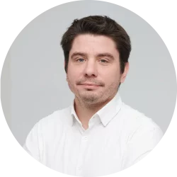 Homme en chemise blanche, fond neutre.